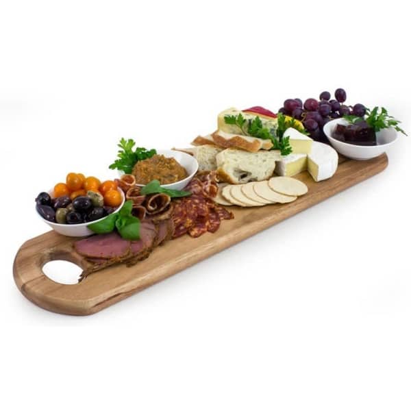 A wooden serving platter with assorted cheeses, cold cuts, grapes, olives, and dips in small bowls.