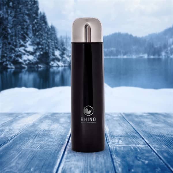 A drink bottle in black with a silver lid, featuring a logo, set against a snowy landscape.