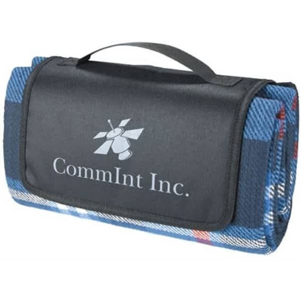 A folded blue picnic rug with a black carrying handle and a logo on the surface.