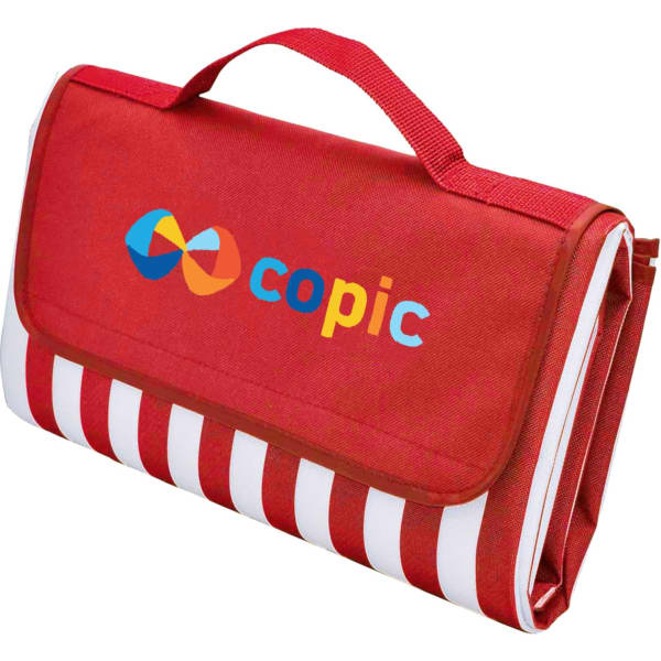 A red picnic rug with a striped pattern and a handle, featuring a logo on the front.