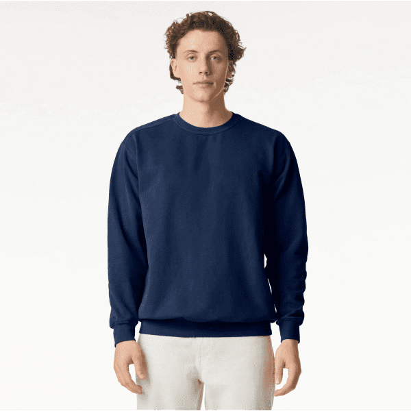 A navy blue crewneck sweatshirt on a model, featuring long sleeves and a logo on the front.
