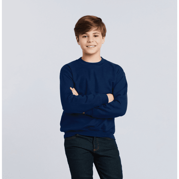 A youth sweatshirt in navy blue, worn by a boy with crossed arms, smiling against a light background.