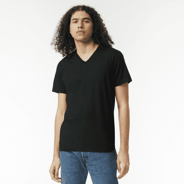 A black unisex V-neck T-shirt displayed on a model with curly hair, paired with blue jeans.