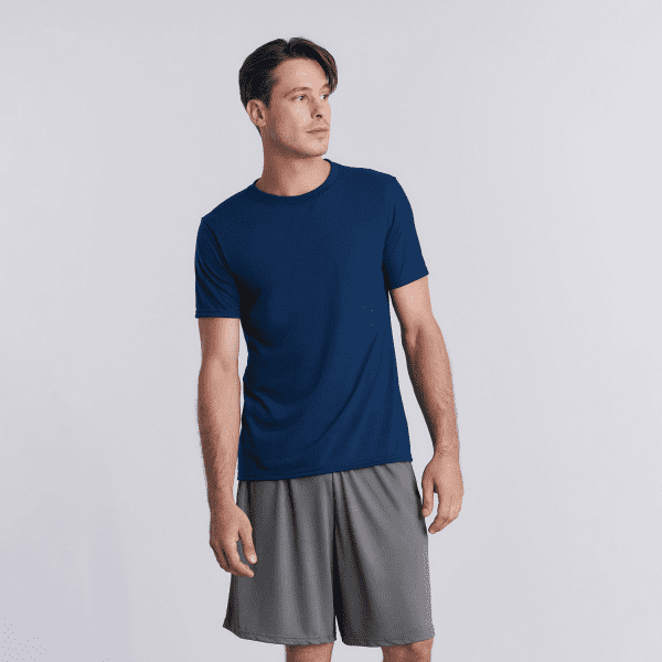 A navy performance adult t-shirt displayed on a model, paired with grey shorts. The shirt features a logo.