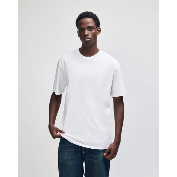 A white unisex short sleeve T-shirt displayed on a model, with a simple design and a logo on it.