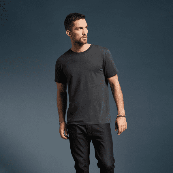 A dark grey adult T-shirt with a classic cut, featured on a model against a solid background. The shirt has a logo.