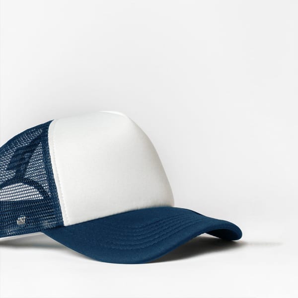 A blue and white snap back trucker cap with mesh detailing and a logo on the front.
