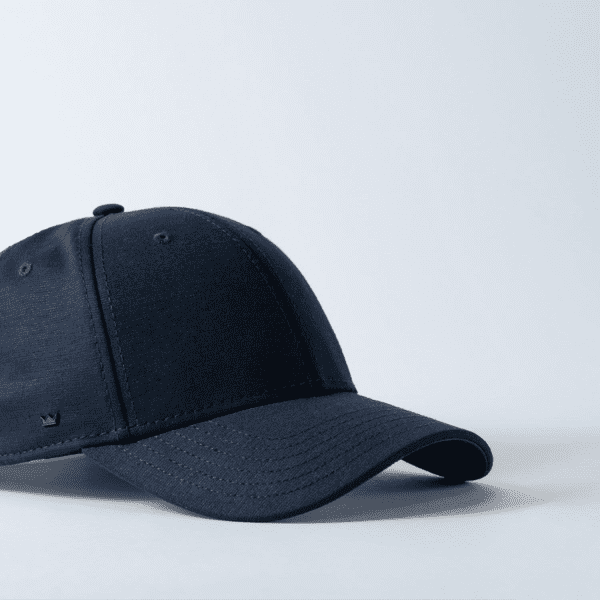 A navy 6 panel baseball cap with a curved brim and a small logo on the side.