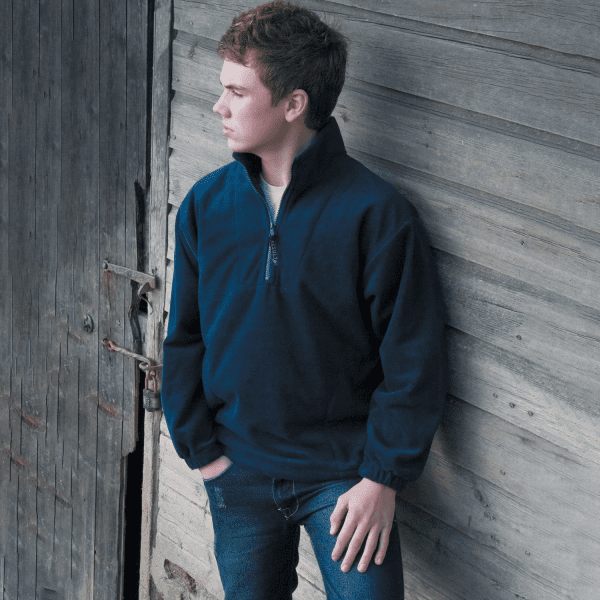 A navy Polartherm quarter zip jumper, featuring a collar and elasticated cuffs, worn by a young man.
