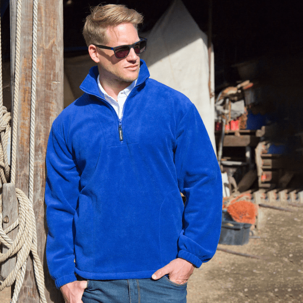 A blue polar fleece quarter zip top with a small logo, featuring a stand-up collar and long sleeves.