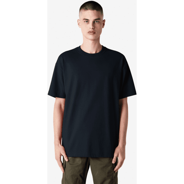 A plain navy blue heavyweight T-shirt with a relaxed fit, displayed on a model. It features a logo on the sleeve.
