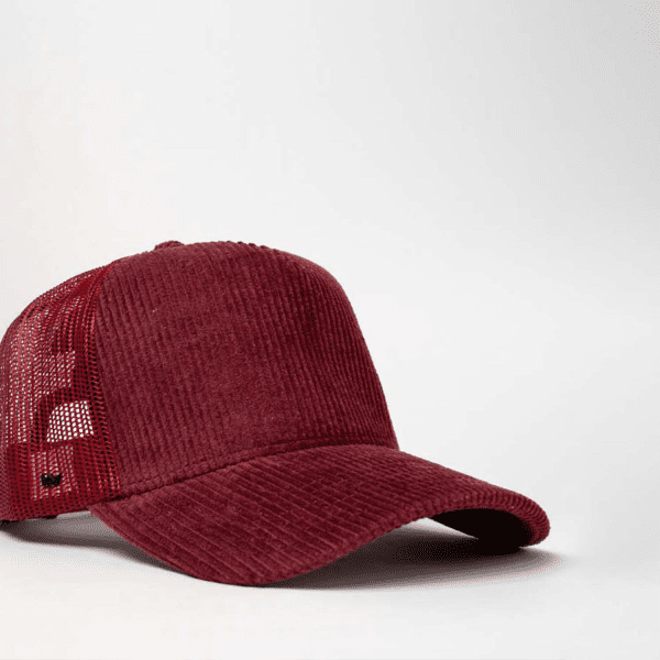 A burgundy cord trucker snapback cap featuring a mesh back and a logo.