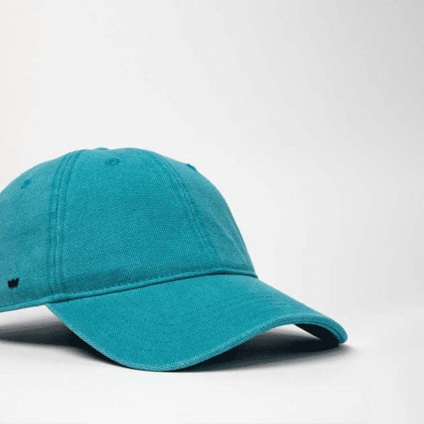 A teal cotton canvas unstructured 6 panel cap with a logo on the front.