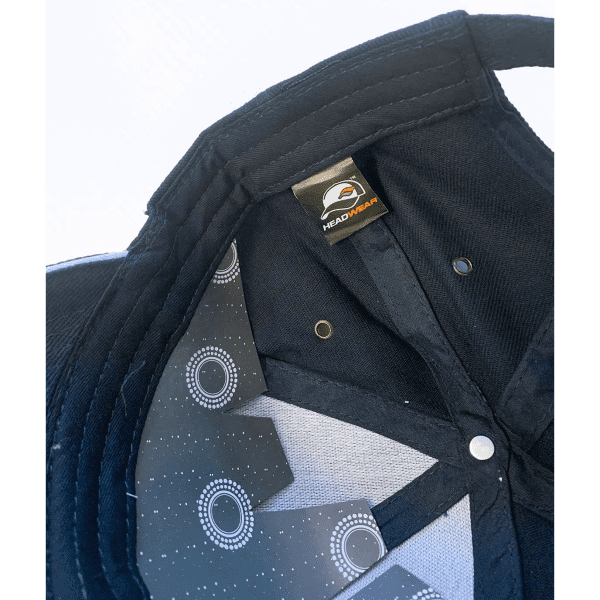 A black cap featuring a logo and patterned lining inside, showcasing its inner construction.