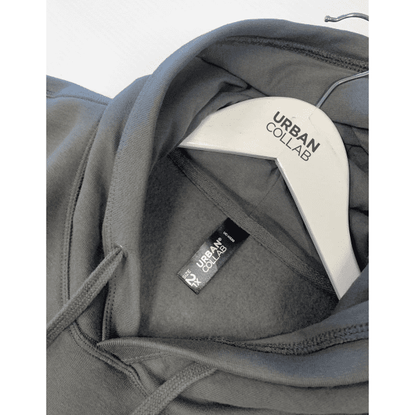 A grey hoodie with a smooth interior, featuring a hanging tag that includes a logo on it.