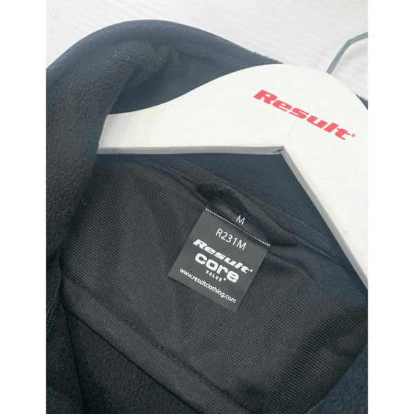 A black jacket with a tag displaying size M, hanging on a white coat hanger. It features a brand logo.