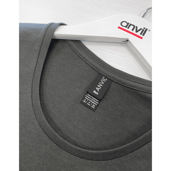 A black T-shirt with a round neck, featuring a label and a hanger with a logo.