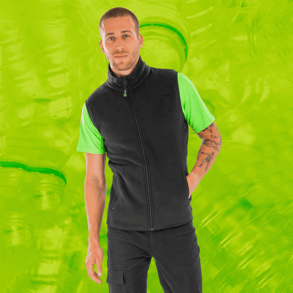 A black and green Recycled Fleece Polarthermic Vest worn by a model against a vibrant green background.