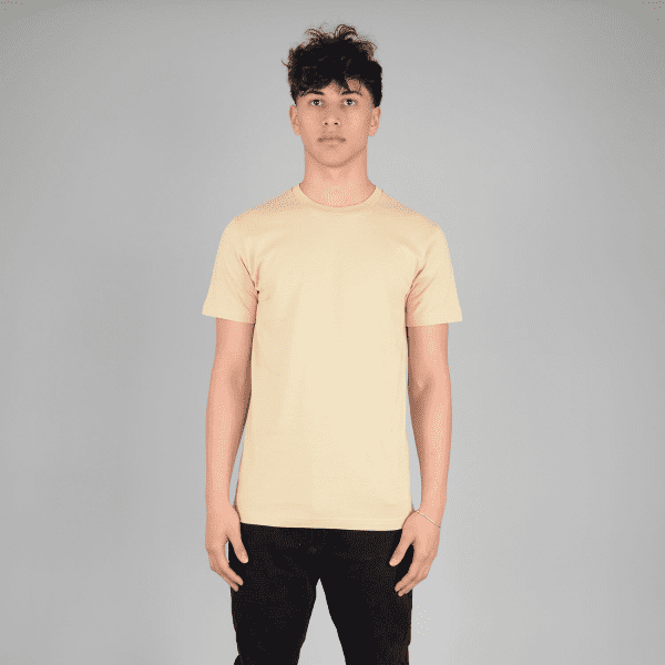 A plain peach T-shirt featuring a crew neck and short sleeves, displayed on a model against a grey background.