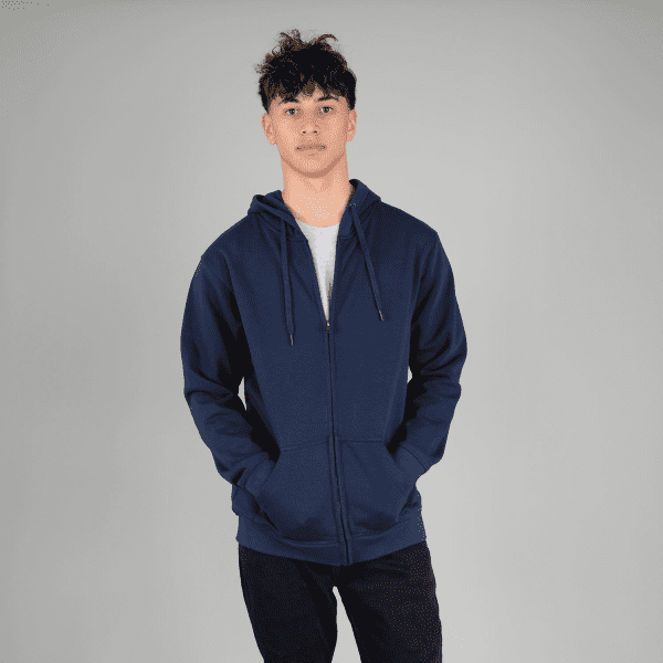 A navy zip hoodie featuring a front pocket and a hood, modelled by a person with hands in pockets.