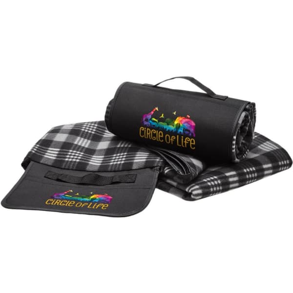 A black and grey checkered blanket with a carrying strap, featuring a colourful logo.