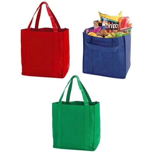 Three non-woven shopping totes in red, blue, and green, one filled with snacks. Each bag has double handles and a logo.