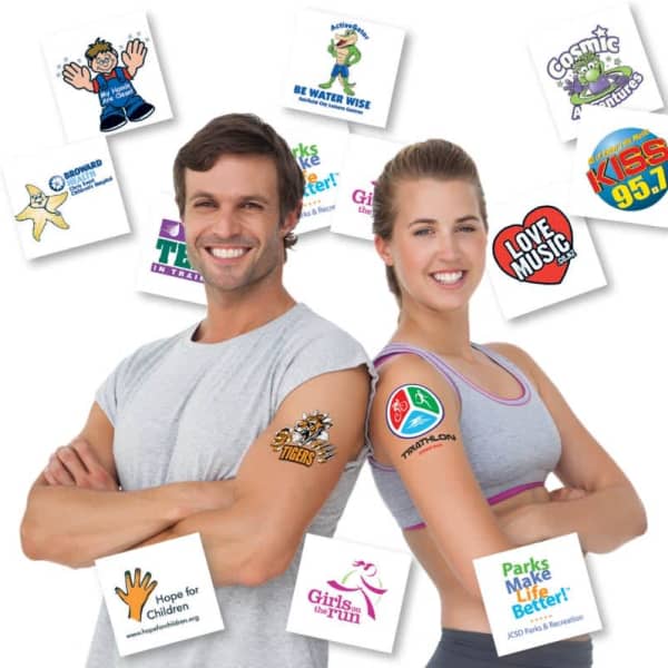 A man and woman smiling, showcasing a variety of colourful temporary tattoos on their arms, with logos in the background.