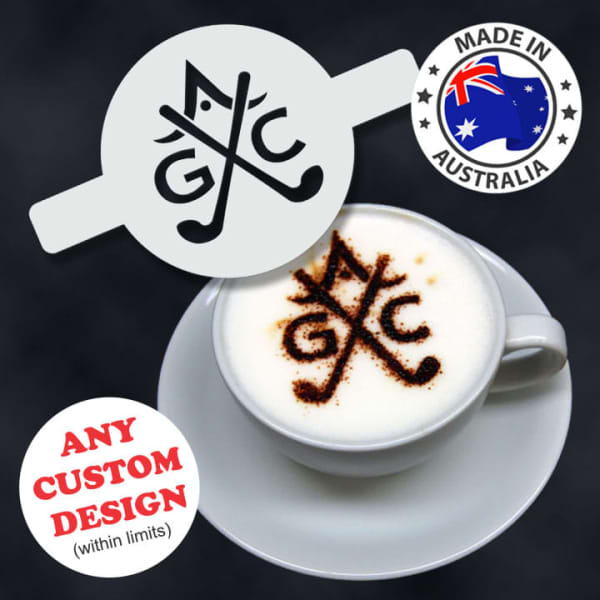 A coffee cup featuring a frothy beverage topped with a stencil pattern. The cup is white against a dark background.