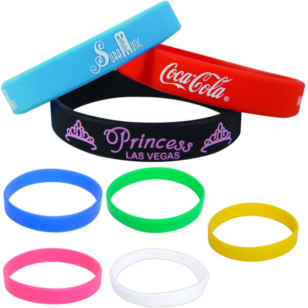 A collection of silicone wristbands in various colours including blue, red, black, green, pink, yellow, and white, featuring logos.