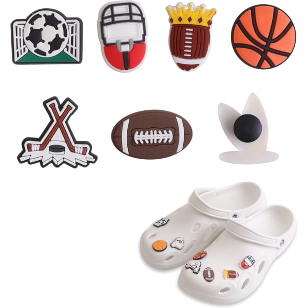 A pair of white Clog shoes with assorted sports-themed charms in green, red, brown, orange and black.