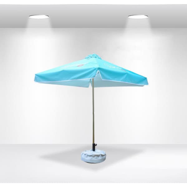 A light blue patio umbrella with valances and a base, featuring a logo, set against a plain background.
