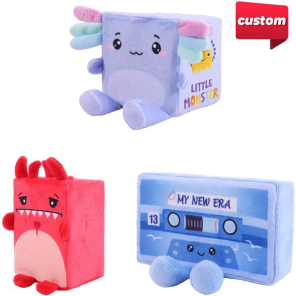 A plush toy set featuring a pastel blue monster, a red monster, and a blue cassette tape. Each has a playful design.