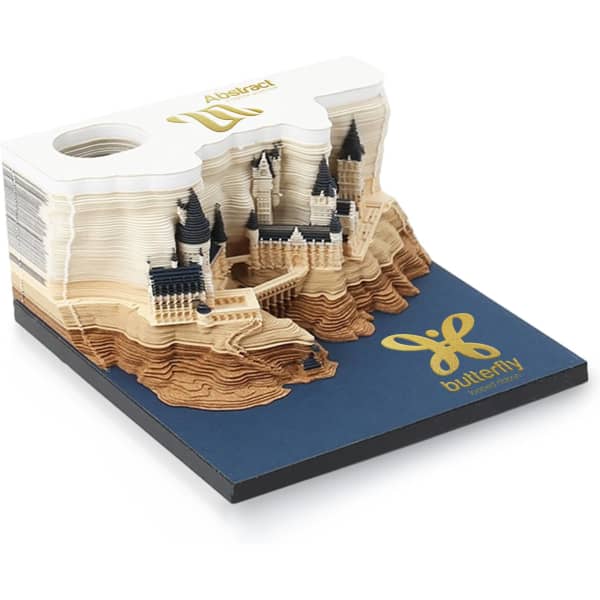 A 3D paper carving notepad in cream and blue featuring an intricate castle design atop a layered landscape.