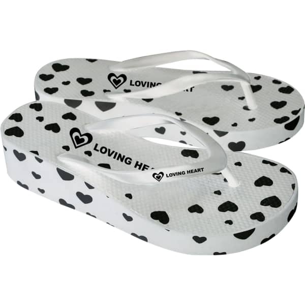 A pair of white platform thongs featuring a heart pattern and a logo on the strap.