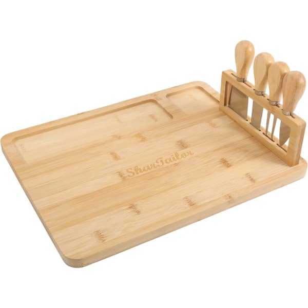 A bamboo cheese board with a rectangular shape and a set of four wooden-handled knives.