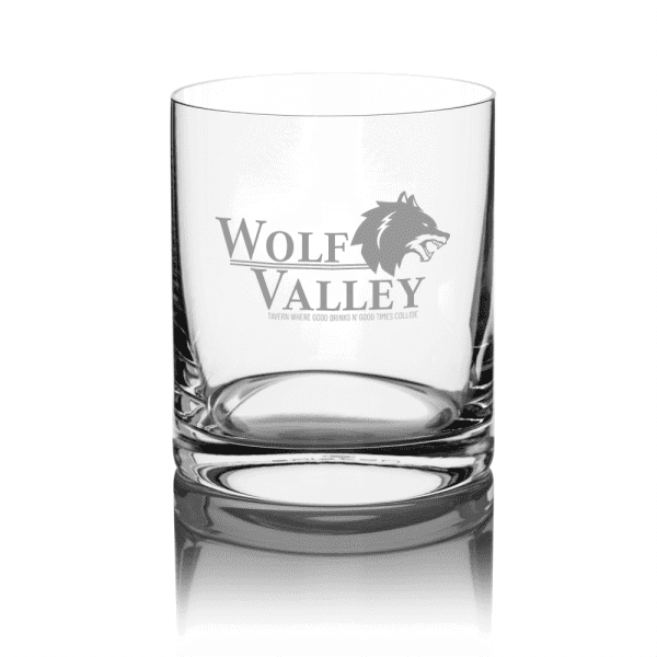 A clear glass whisky tumbler featuring a logo and a sturdy base. The glass has a polished finish.