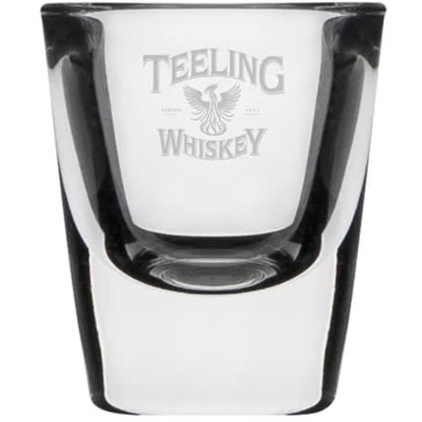 A clear glass shot glass with a logo, featuring a classic design and a smooth finish.