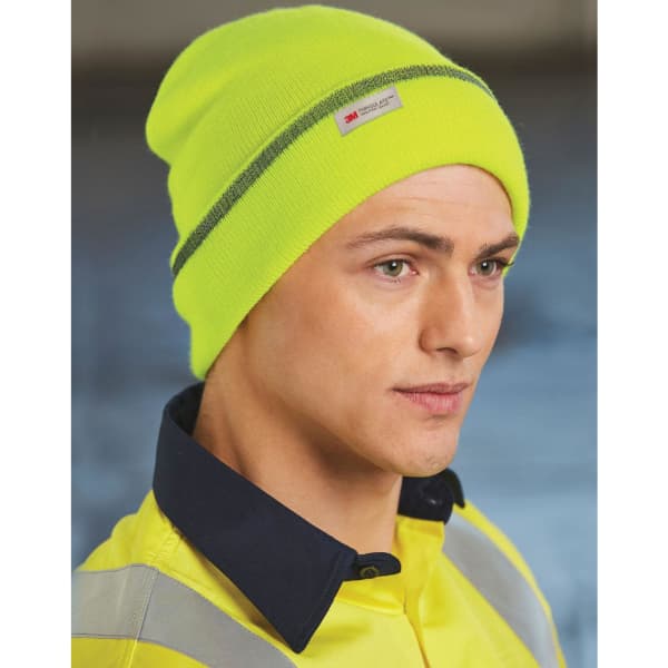 A bright neon yellow cuff beanie with a grey stripe, fitted snugly on a model's head. It features a brand logo tag.