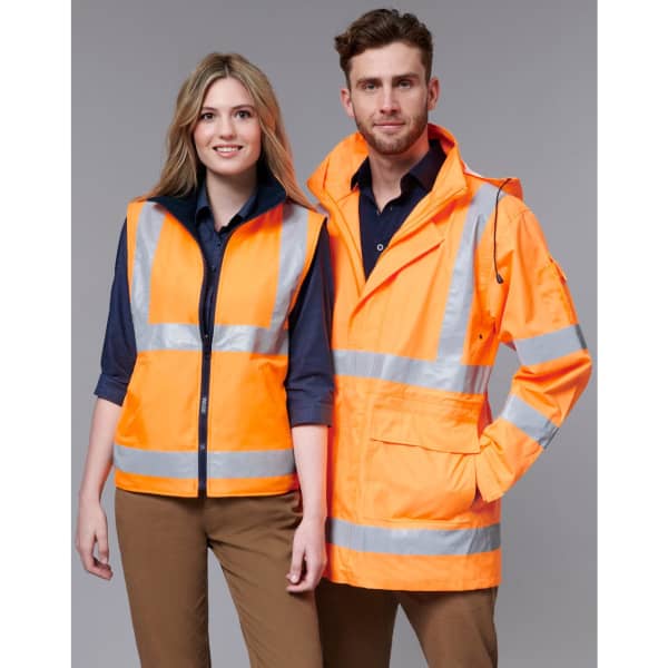 A safety jacket in bright orange with reflective stripes, displayed on two models, one male and one female.
