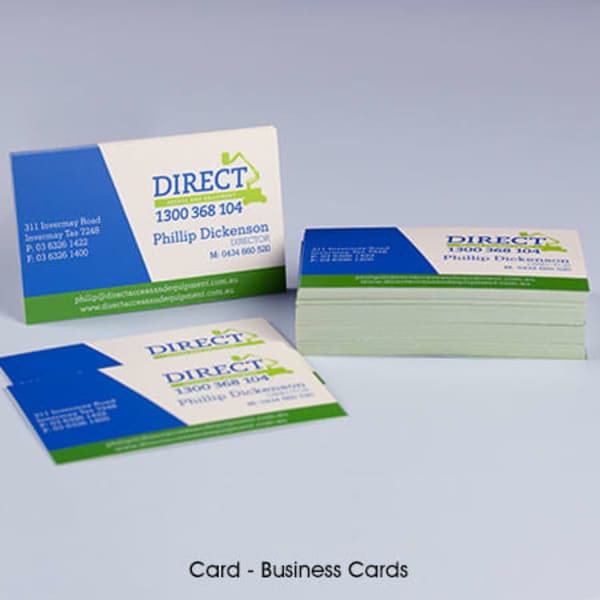 A stack of business cards in green and blue featuring contact details and a logo.
