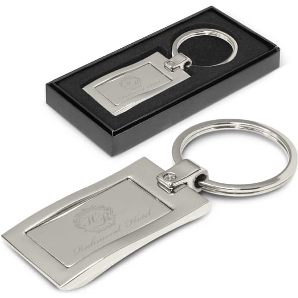 A silver metal key ring with a sleek rectangular design, presented in a black gift box.