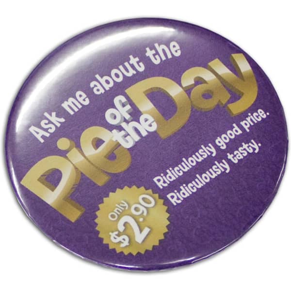 A round, 75mm purple button badge with a glossy finish and a logo.