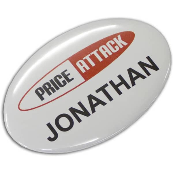 An oval button badge in white with a red and black logo and the name 