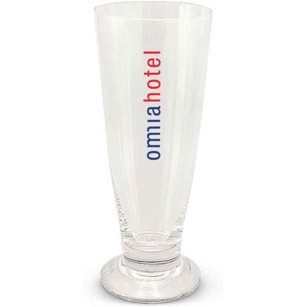 A tall glass beer glass with a clear, smooth surface and a base, featuring a logo in red and blue.