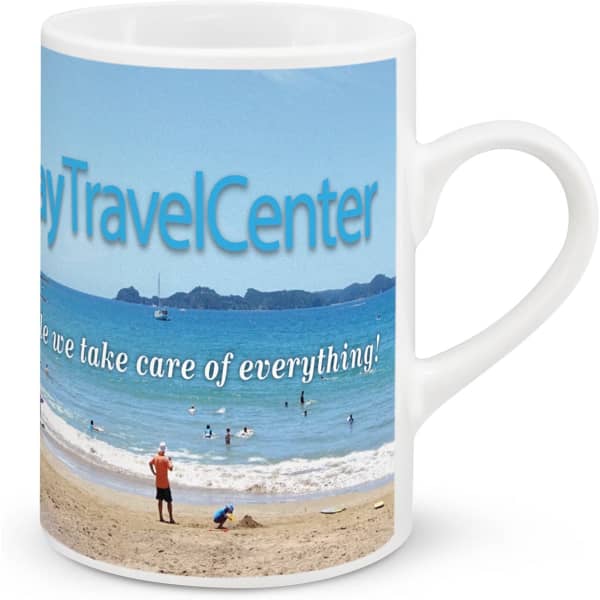 A coffee mug featuring a beach scene, predominantly blue with a white handle and a logo on one side.