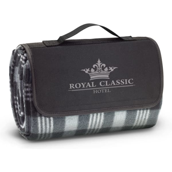 A folded picnic blanket in grey and black, featuring a logo, with a handle for easy carrying.