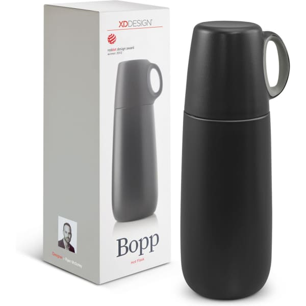 A drink bottle in matte black with a green handle, alongside its packaging featuring a logo.