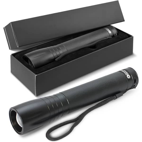 A black torch with a textured grip, placed in a black box with padding, featuring a wrist strap.