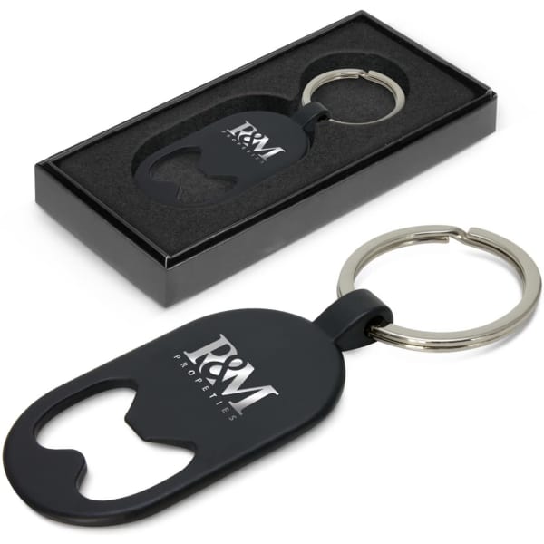 A drink bottle opener key ring in black, displayed in a box with an insert, featuring a logo on the opener.