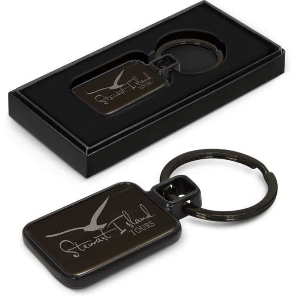 A black key ring with a rectangular design, presented in a sleek black box. Features a logo on the key ring.